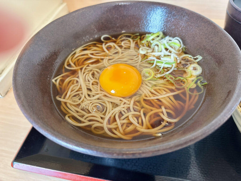 生たまごの黄身が乗った、ゆで太郎の温かい月見そばのアップ