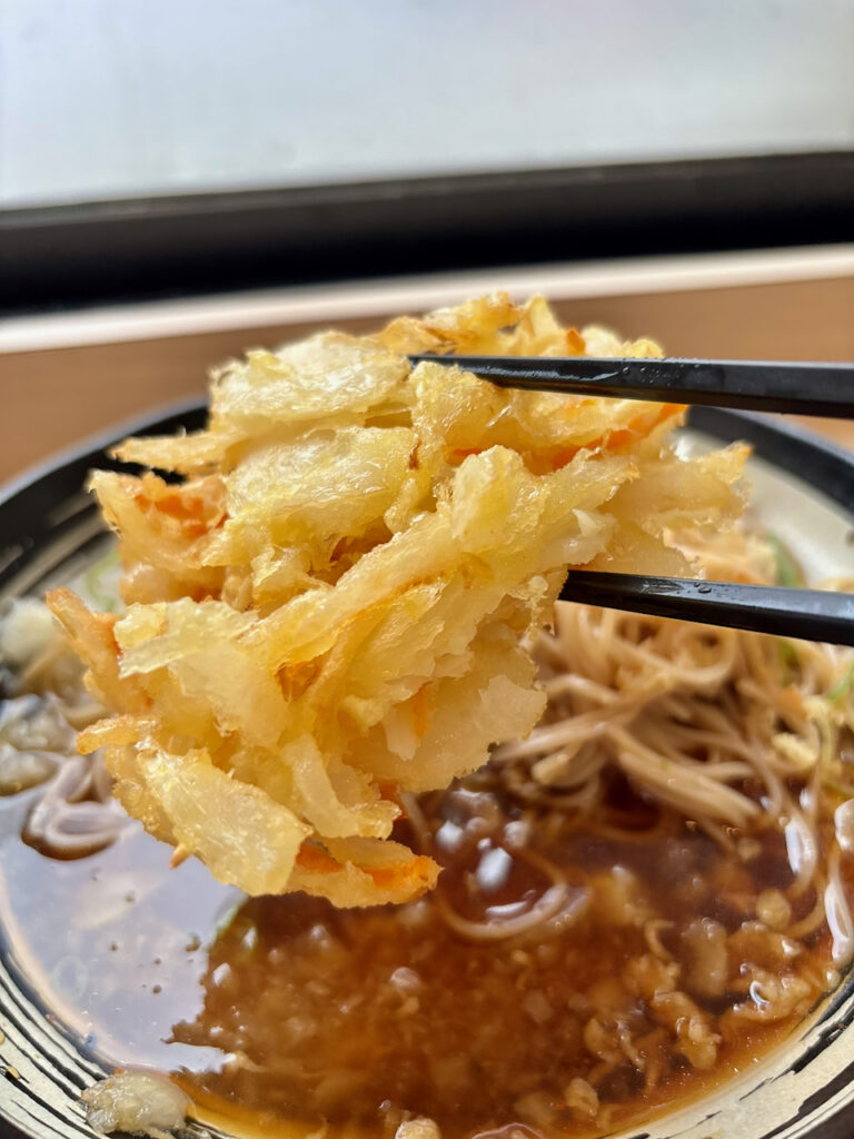 ゆで太郎の野菜かき揚げを箸で持ち上げた写真