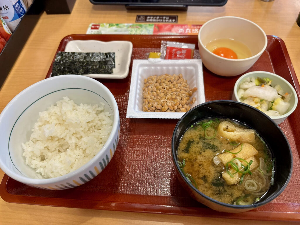 なか卯のこだわり卵の納豆朝食(小盛)がトレーに乗って配膳された様子。お味噌汁とアレンジ中どんぶりの全体写真