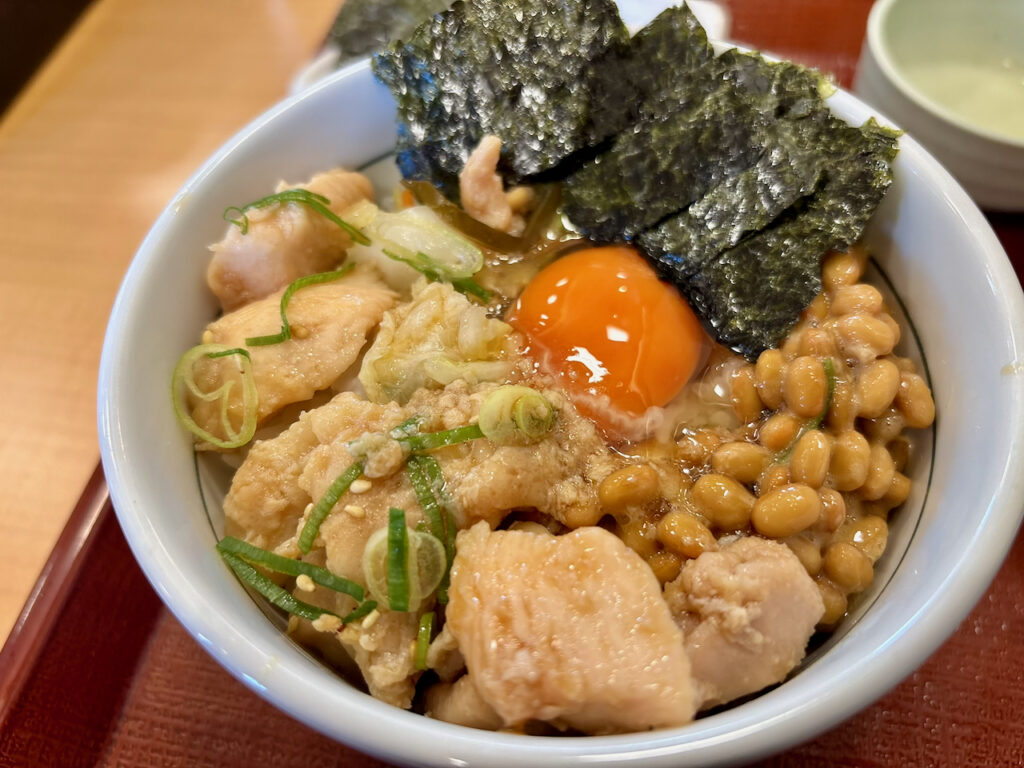ご飯の上に鶏肉・納豆・こだわり卵・おしんこ・海苔を盛り付けた全部のせ丼