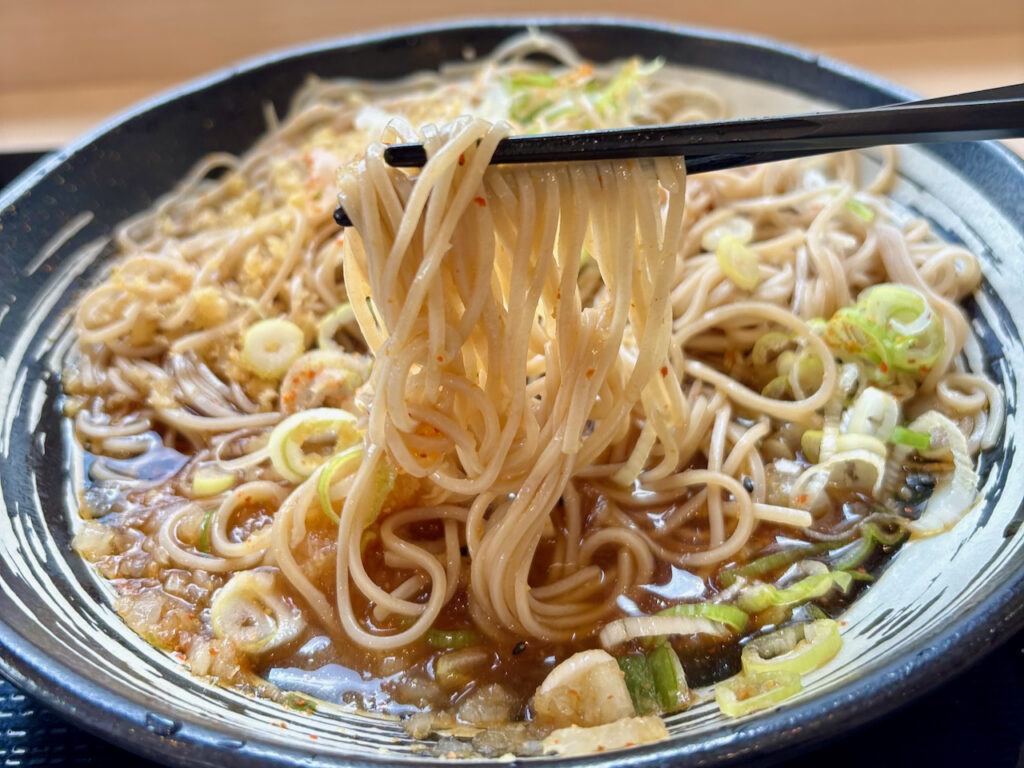 おつゆと鬼おろしがしっかり絡んだゆで太郎のそばを箸ですくい上げた様子