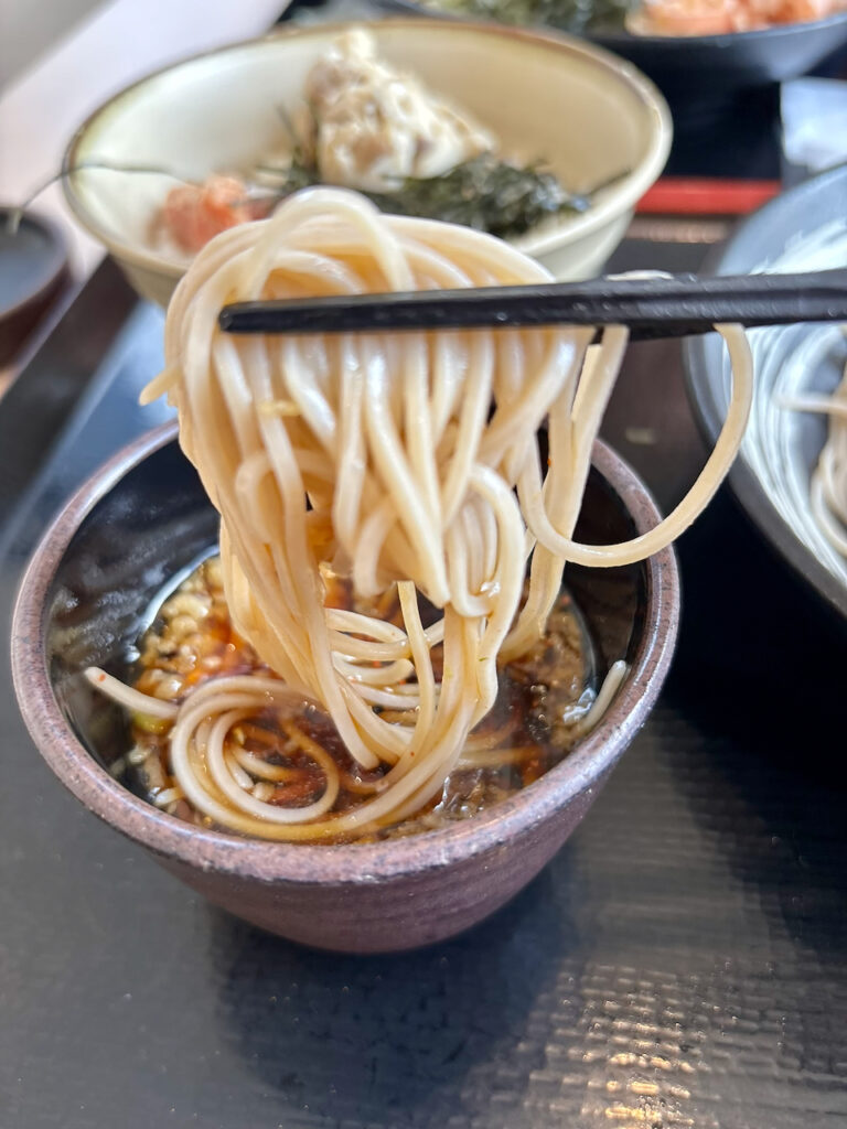 ゆで太郎の冷たいお蕎麦を箸で持ち上げている様子