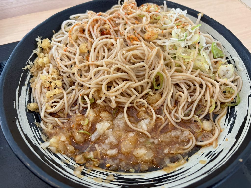 蕎麦の上にねぎ、天かす、すりごま、七味、赤鬼をトッピングした状態