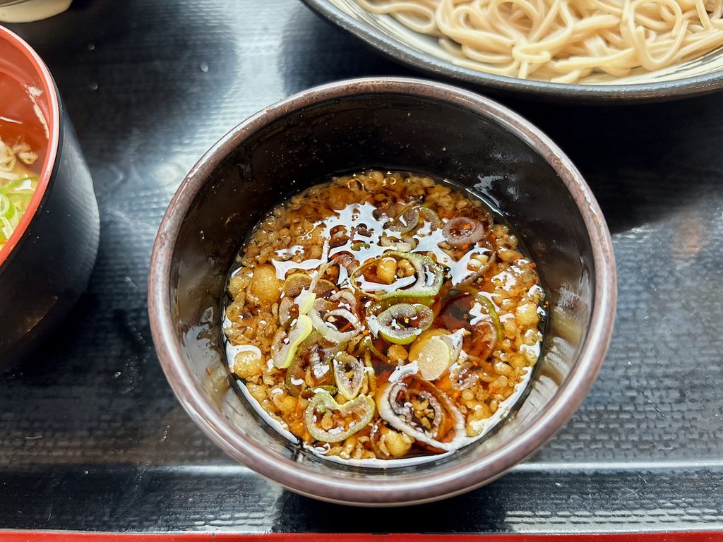 ねぎ・七味・揚げ玉を入れた特製つゆ。清涼感とパンチが両立